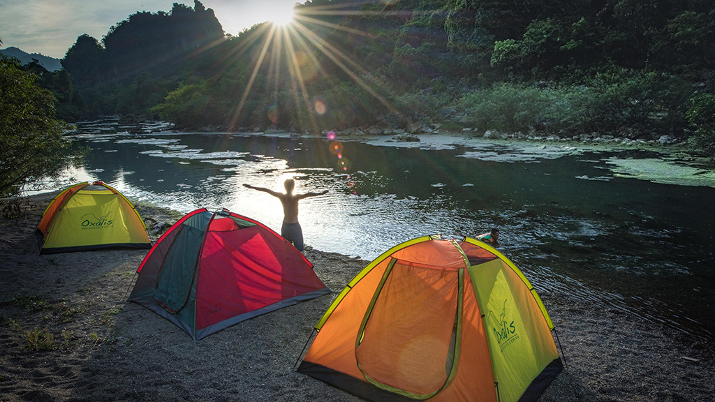 Visitors are seen camping on the shore of a stream that flows out of a cave in Quang Binh Province, Vietnam. Photo: N.V.H.