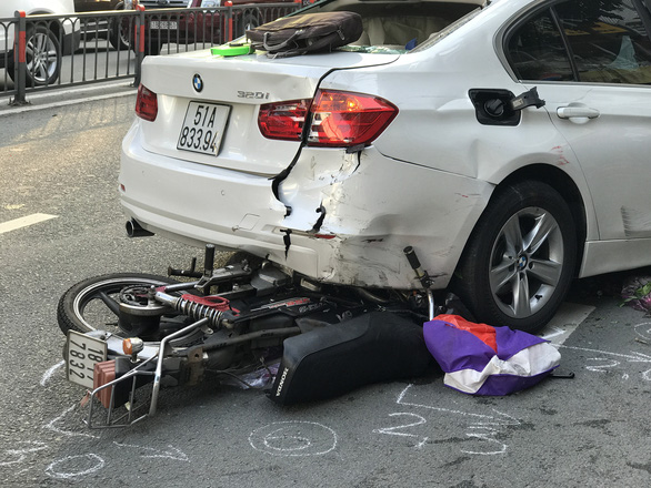 A motorbike is stuck under a car after a tractor-trailer slammed into them in District 10, Ho Chi Minh City, September 22, 2020. Photo: Le Phan / Tuoi Tre