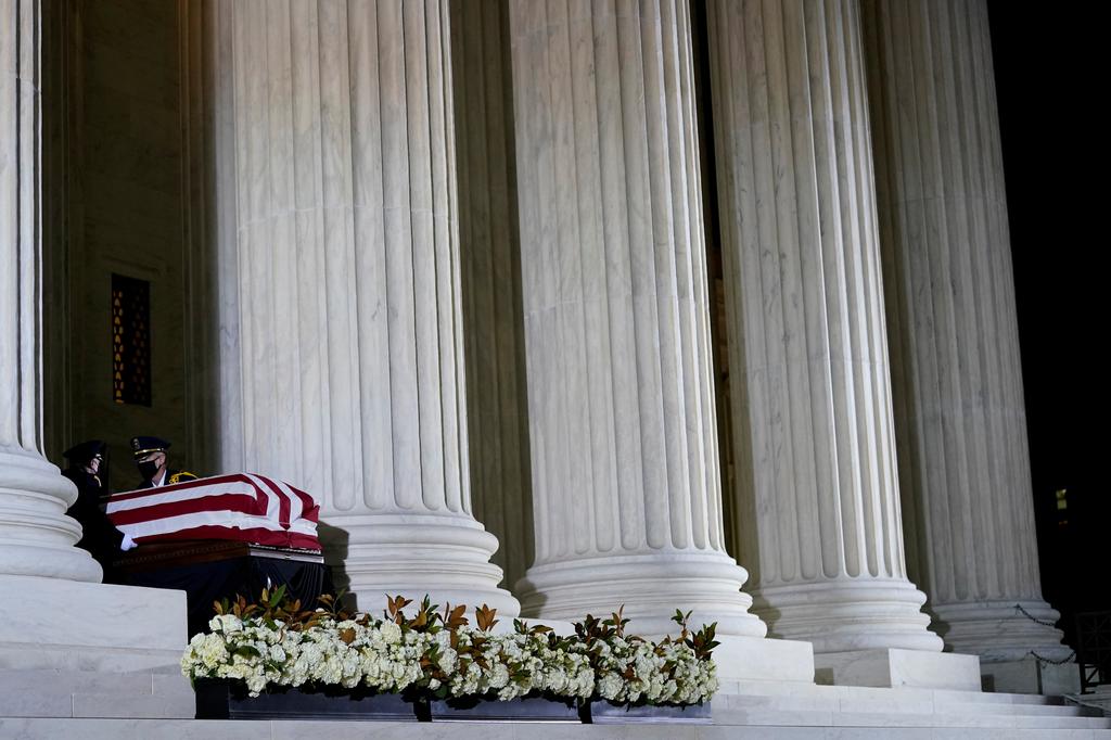A Supreme Court Honor Guard salutes before moving the flag-draped casket of Justice Ruth Bader Ginsburg back into the court as Ginsburg lies in repose under the Portico at the top of the front steps of the U.S. Supreme Court building in Washington, U.S., September 24, 2020. Photo: Reuters