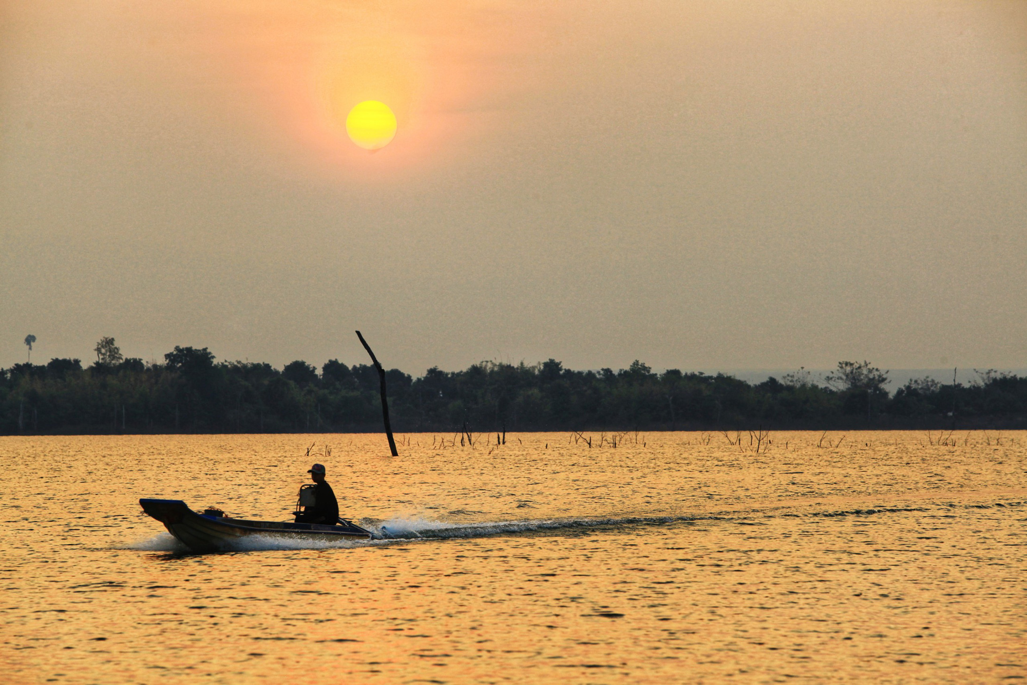 A person drives a canoe across Se San lake in Kon Tum Province, Vietnam. Photo: Chieu Ly / Tuoi Tre
