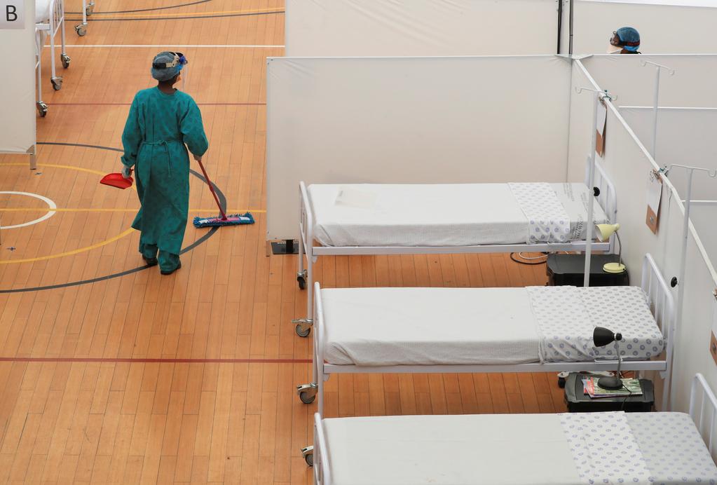 A health worker walks between beds at a temporary field hospital set up in a sports complex by Medecins Sans Frontieres (MSF) during the coronavirus disease (COVID-19) outbreak in Khayelitsha township near Cape Town, South Africa, July 21, 2020. Photo: Reuters