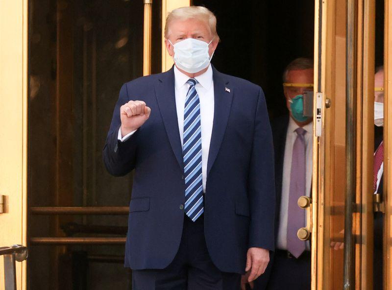 U.S. President Donald Trump makes a fist as he walks out the front doors of Walter Reed National Military Medical Center after a fourth day of treatment for the coronavirus disease (COVID-19) while returning to the White House in Washington from the hospital in Bethesda, Maryland, U.S., October 5, 2020. Photo: Reuters