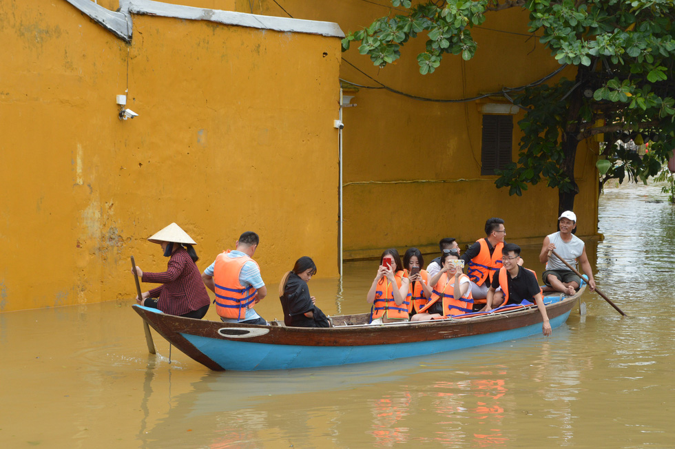 Residents of Hoi An City take tourists around the ancient town, which has been flooded due to torrential rains, on a boat in this photo taken in Hoi An City, Quang Nam Province on October 12, 2020. Photo: B.D. / Tuoi Tre