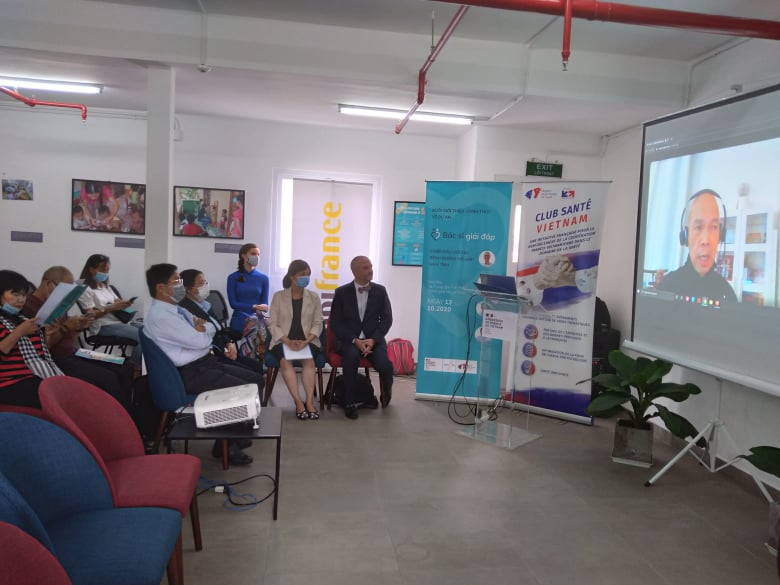Dr. Dinh Xuan Anh Tuan (on a screen), professor of respiratory physiology and medicine at Université de Paris, shares his thoughts about the 'Doctors Answer' website via video link at its launch at Center Medical International in Ho Chi Minh City, October 13, 2020. Photo: Kim Thoa / Tuoi Tre News