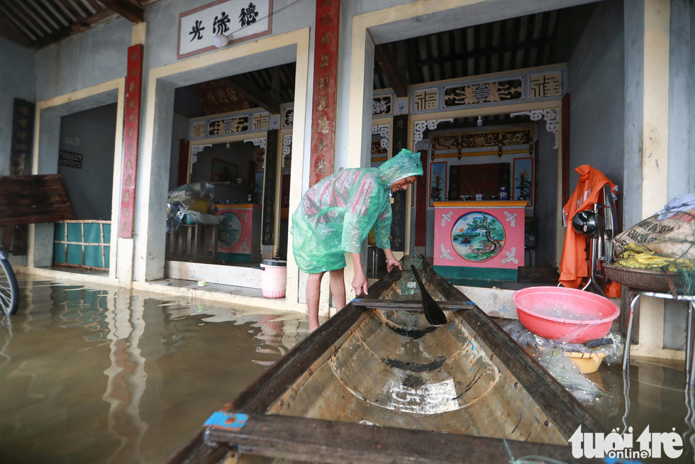 Local man Truong Dinh Cuong ties his boat to a pole in front of his house in flooded Quang Phuoc Commune, Quang Dien District, Thua Thien-Hue Province on October 16, 2020. Photo: Nguyen Khanh / Tuoi Tre