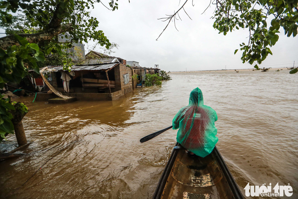 Local man Truong Dinh Cuong commutes on a boat in flooded Quang Phuoc Commune, Quang Dien District, Thua Thien-Hue Province on October 16, 2020. Photo: Nguyen Khanh / Tuoi Tre