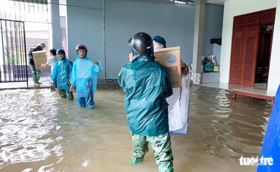 Functional forces from Ha Tinh Province help residents to move their assets from a flooded house. Photo: Quy Ngoc / Tuoi Tre