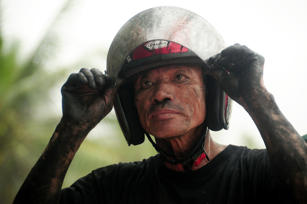 A man has his face and entire body get dirty while building a temporary revetment to protect the coast against the high waves in Hoi An City, Quang Nam Province, Vietnam, October 20, 2020. Photo: T.B.Dung / Tuoi Tre