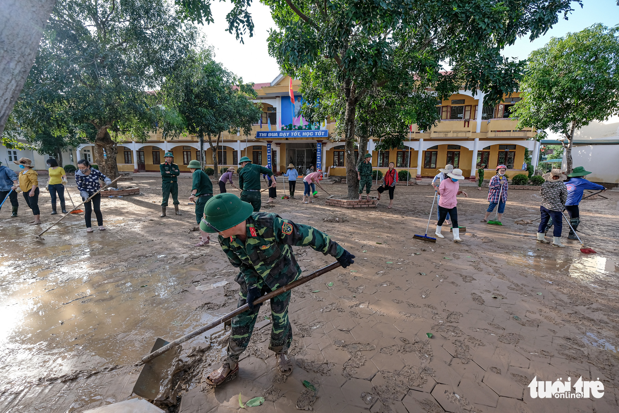 Military officers and teacher clean up mud at a middle school in Ha Tinh Province, Vietnam, October 22, 2020. Photo: Nam Tran / Tuoi Tre