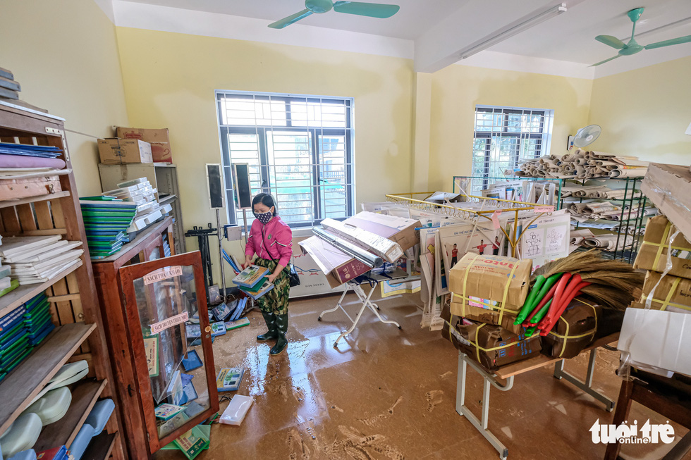A teacher of Cam Quang Elementary School in Ha Tinh Province cleans up the school office after flooding. Photo: Nam Tran / Tuoi Tre