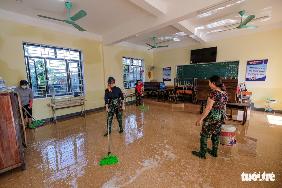 Teachers of Cam Xuyen District in Ha Tinh Province clean up a classroom of Cam Quang Elementary School. Photo: Nam Tran / Tuoi Tre