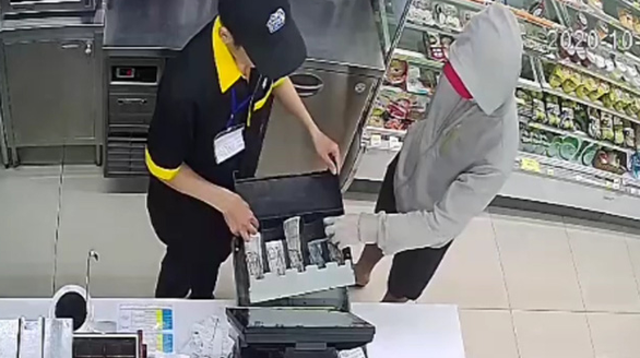 Pham Ngoc Anh Tuan takes money from the cashier’s drawer inside a Ministop convenience store on Au Co Street, Tan Phu District, Ho Chi Minh City, October 12, 2020 in this screenshot taken from CCTV footage.