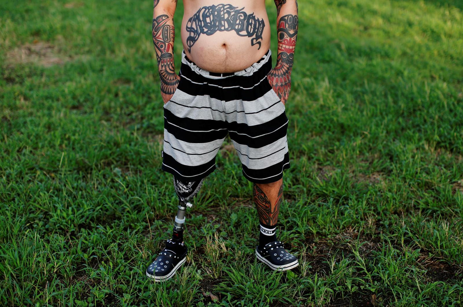 Office worker Hideyuki Togashi, 48, shows his tattoos as he poses for a photograph at a park near his house in Tokyo, Japan, September 7, 2020. Photo: Reuters