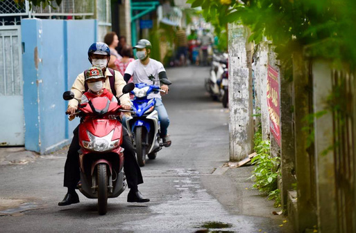 A man carries his son on a motorbike in Ho Chi Minh City, November 11, 2020. Photo: Quang Dinh / Tuoi Tre