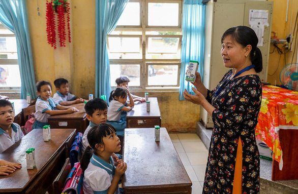 A teacher introduces the school milk program to students in a primary school in Cu Chi District, Ho Chi Minh City.