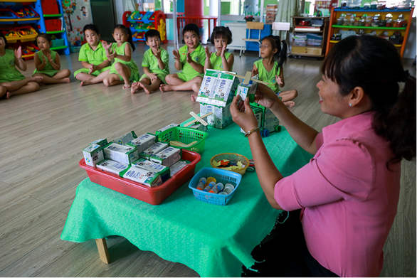 A teacher teaches students to make toys from milk boxes in this photo taken at a primary school in Cu Chi District, Ho Chi Minh City.