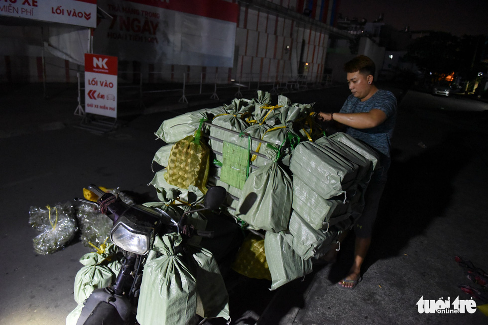 Nguyen Hoang Dong from Tay Ninh Province loads insect bags onto a truck. Photo: Ngoc Phuong/Tuoi Tre