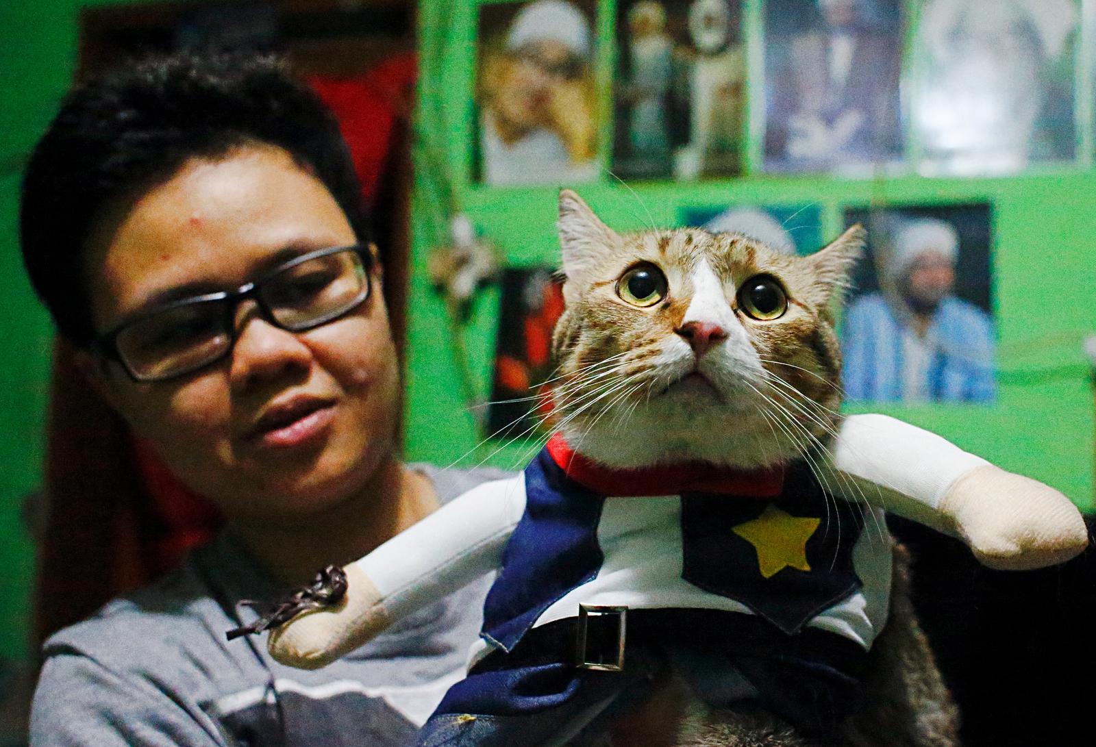 isma Sandra Irawan, 31, carries her cat wearing a cosplay costume, in Jakarta, Indonesia, November 29, 2020. Photo: Reuters