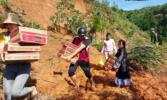 Teachers at Bo Trach Boarding High School for Ethnic Minority Students, in Bo Trach District, Quang Binh Province in north-central Vietnam, carry relief supplies near landslide site in this photo provided by Hoang Duc Hoa, the school’s headmaster