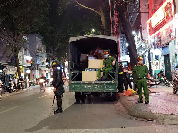Police officers take away large packages of medical items after an inspection at Man Son Minh drugstore in Bien Hoa City, Dong Nai, December 4, 2020. Photo: H.M./ Tuoi Tre