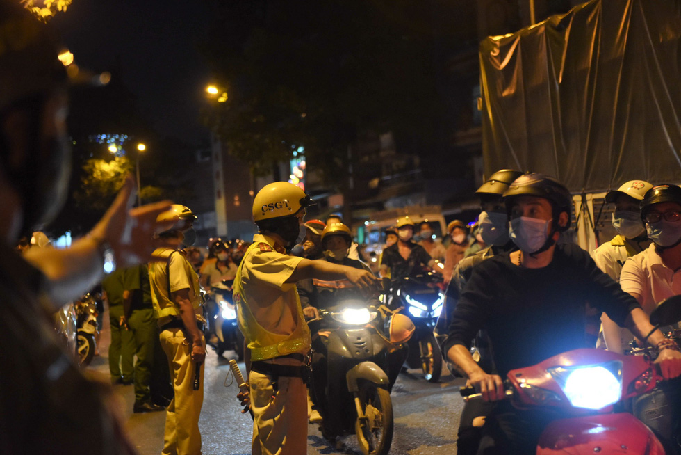 Traffic police officers regulate traffic in front of the mortuary where comedian Chi Tai’s body was temporarily situated in Ho Chi Minh City on December 9, 2020. Photo: Duyen Phan/ Tuoi Tre