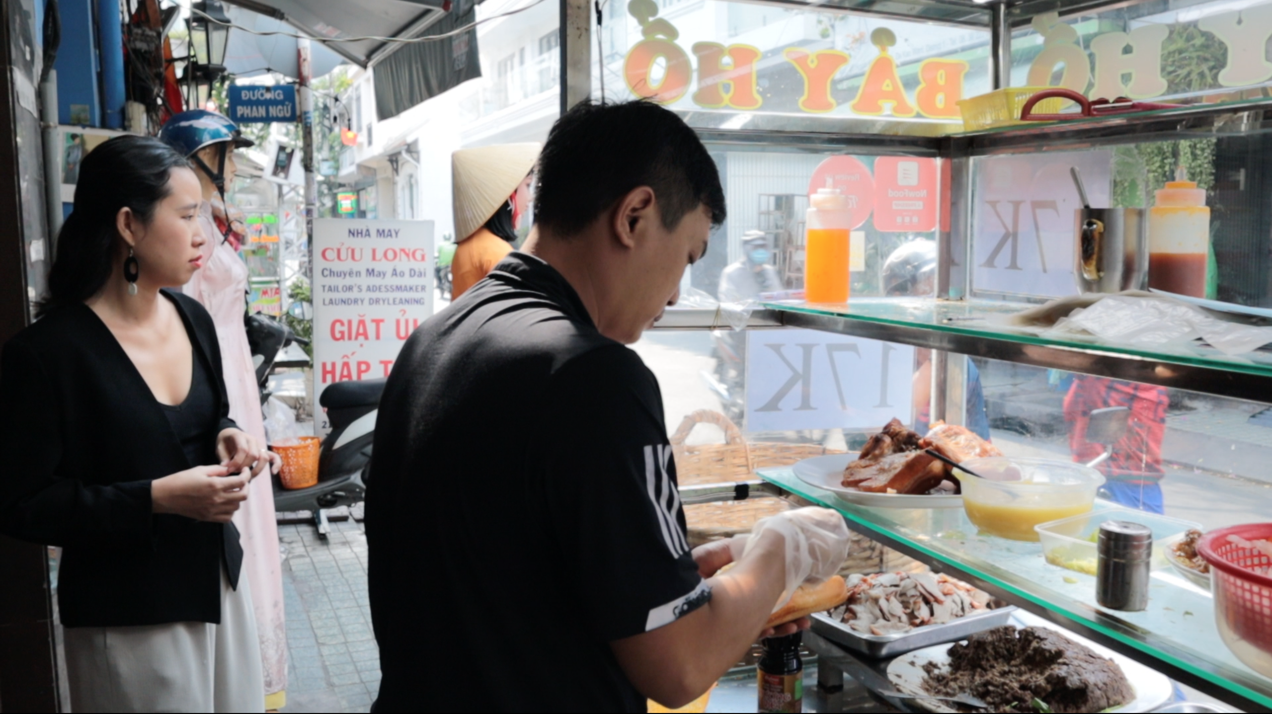 Ho Quoc Dung, the current owner of banh mi Bay Ho cart, prepares banh mi for customers. Photo: Linh To / Tuoi Tre