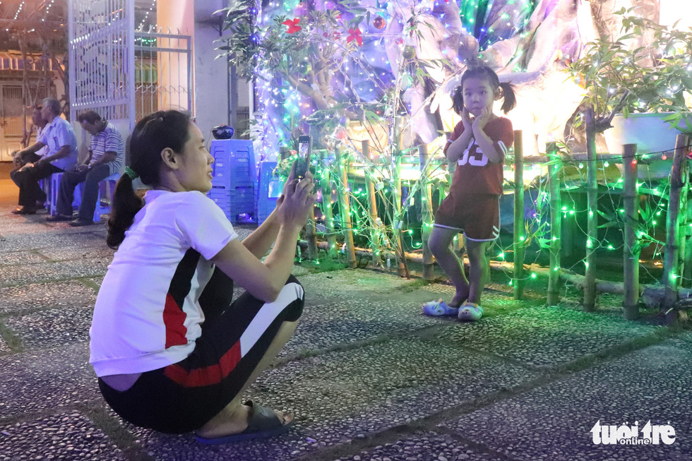 A mother takes a photo of her children at the Our Lady of Perpetual Help Church in Ho Chi Minh City. Photo: Nhat Thu / Tuoi Tre
