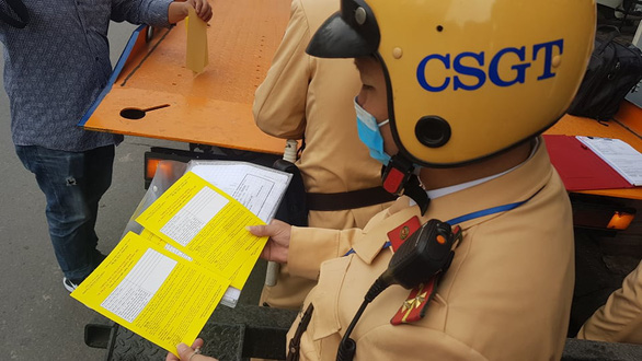 A traffic police officer issues a parking ticket on a street in Hanoi on December 14, 2020. Photo: Quang Hieu