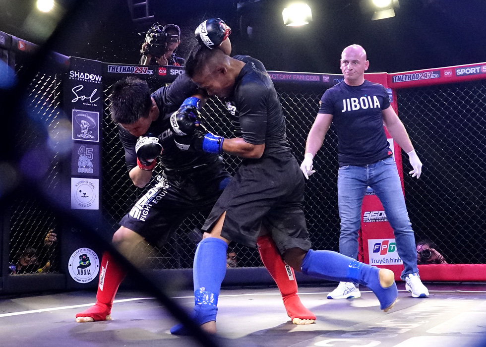 Bui Truong Sinh (red) and Dinh Van Huong (blue) are seen fighting in the first amateur MMA match in Vietnam. Photo: Hoang Tung / Tuoi Tre