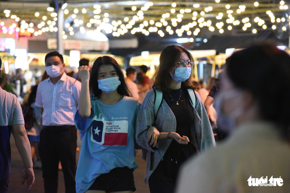 Two girls wearing face masks walk around the Ky Dai Quang Trung pedestrian street in District 10, Ho Chi Minh City. Photo: Ngoc Phuong / Tuoi Tre