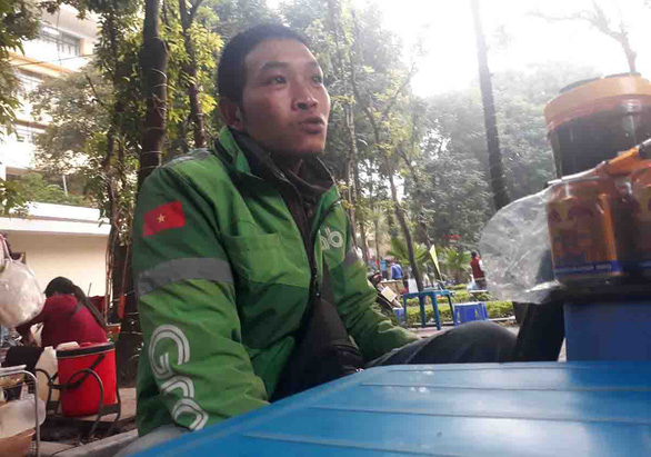 Nguyen Van Bang, in the uniform of multi-service platform Grab, expresses concerns about his livelihood as a motorbike taxi driver operating in Hanoi, Vietnam. Photo: Tam Le/ Tuoi Tre.