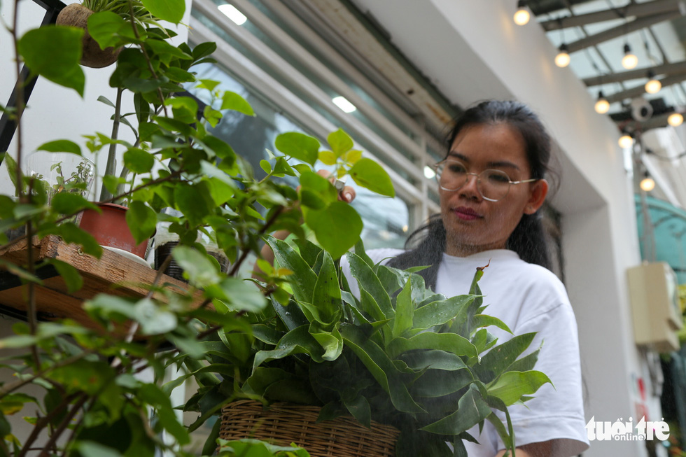 Nguyen Thi Nha Thu, founder of the ‘Zero Dong Program,’ is meticulously taking care of the plants donated by the program’s members. Photo: Huu Huong / Tuoi Tre