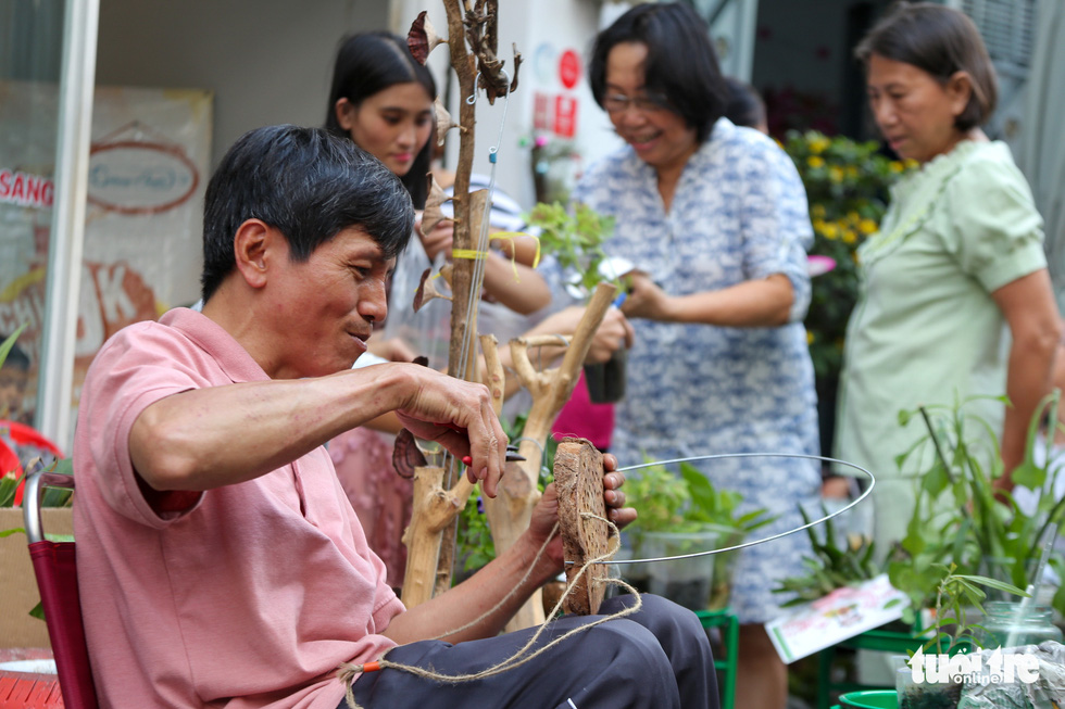 Truong Van Hieu, a member of the program, is making handmade wooden souvenirs for the others. Photo: Huu Huong / Tuoi Tre