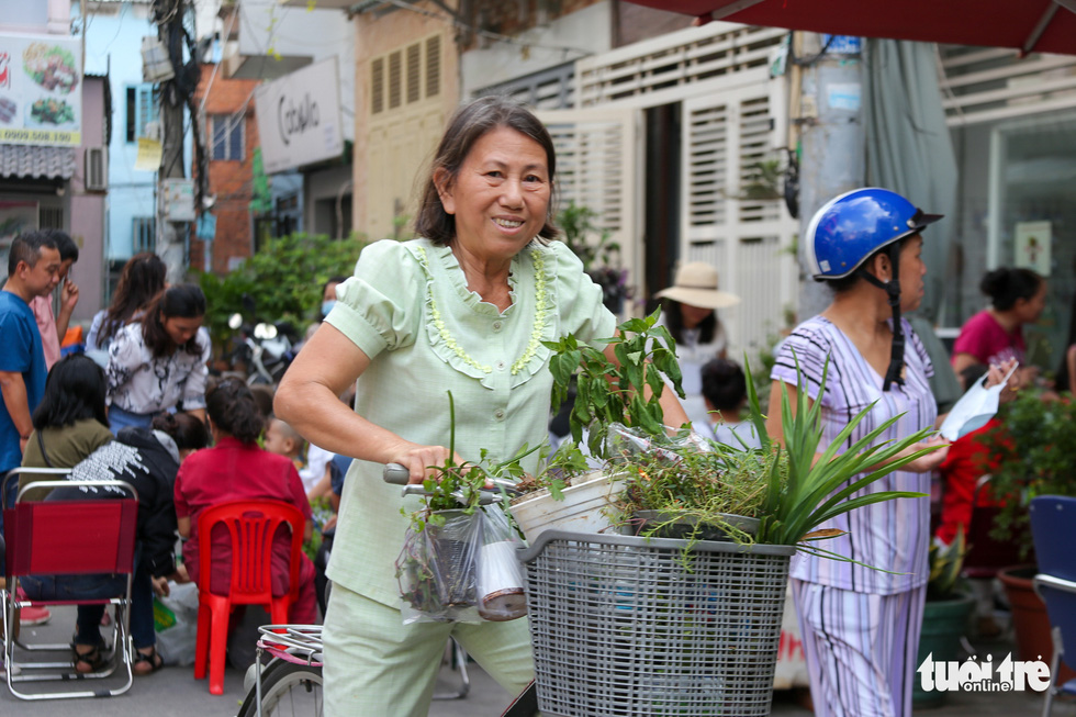 A happy smile of a woman when getting her favorite plants. Photo: Huu Huong / Tuoi Tre