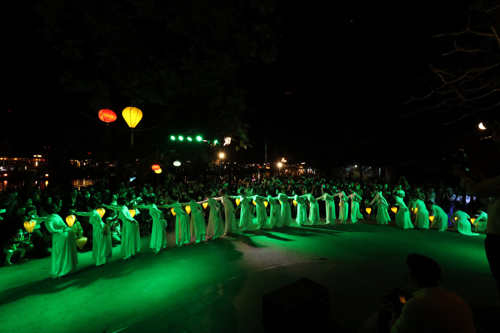Artists donning Vietnam’s traditional ‘ao dai’ walk in a long line with lanterns in their hands in Hoi An Ancient Town, Quang Nam Province, Vietnam, December 28, 2020. Photo: Le Trong Khang / Tuoi Tre