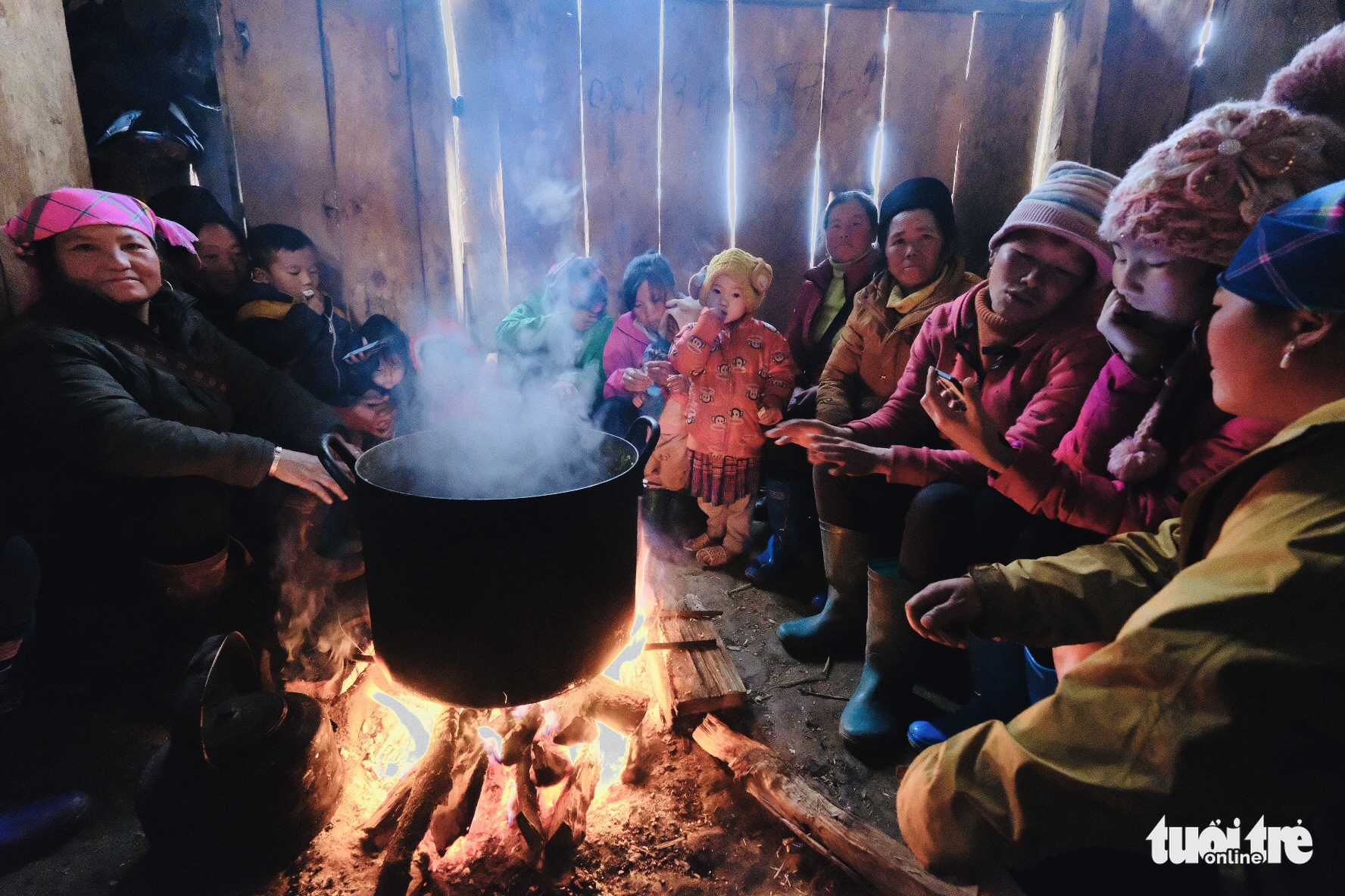 Family members sit by a firewood stove in Sa Pa, Lao Cai Province, Vietnam, December 31, 2020. Photo: Nam Tran / Tuoi Tre
