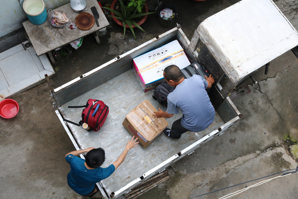 Le Van Duc helps a student load personal belongings onto his delivery tricycle. Photo: Hoang An / Tuoi Tre