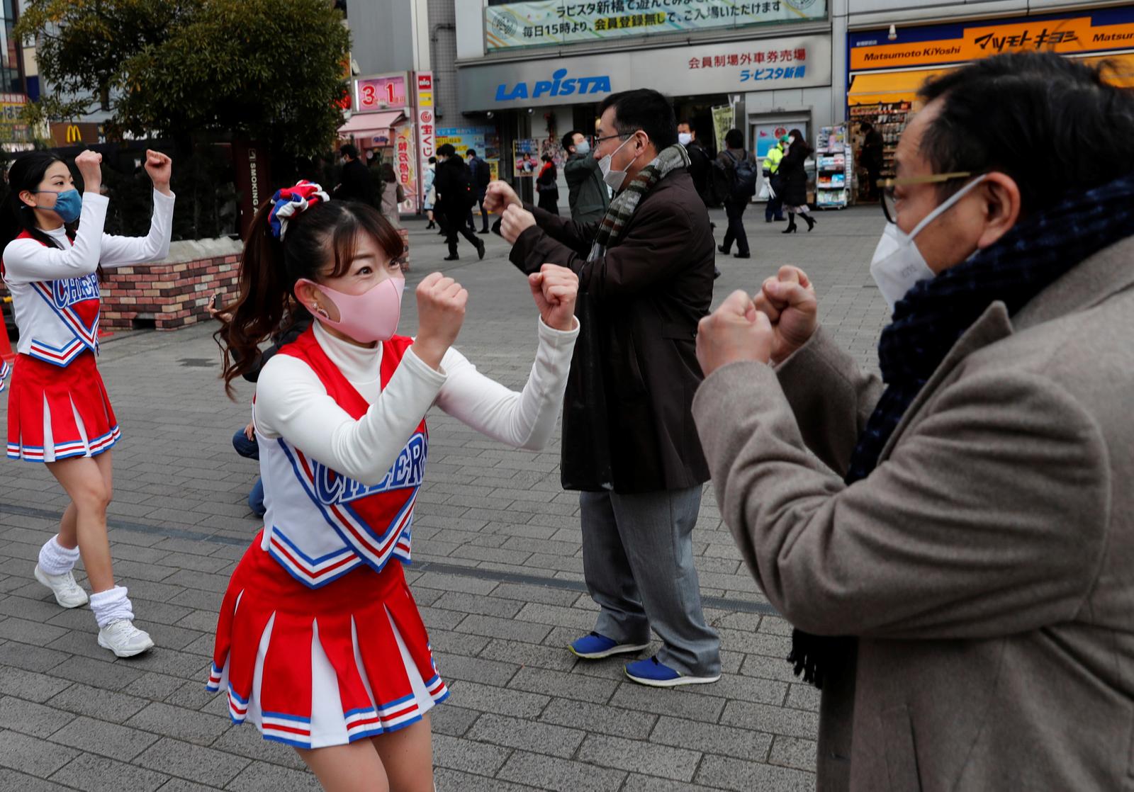 Cheerleaders wearing protective face shields, amid the coronavirus disease (COVID-19) outbreak, cheer people up in front of Shimbashi Station during the commuting hour in Tokyo, Japan, January 7, 2021. Photo: Reuters