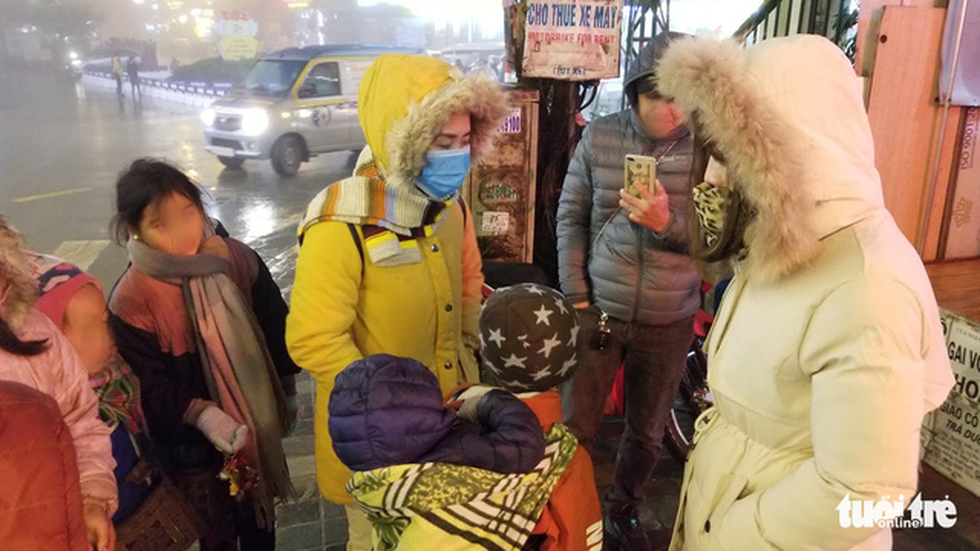 Child vendors surrounds tourists to sell souvenirs in Sa Pa Township. Photo: Vu Tuan / Tuoi Tre