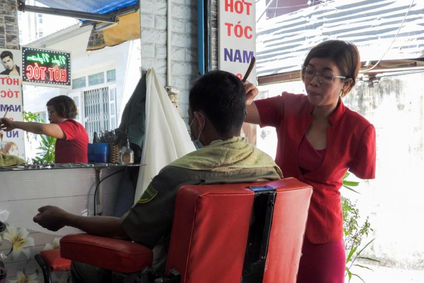 After losing arm, Vietnamese hairdresser styles new ways to cut clients' locks