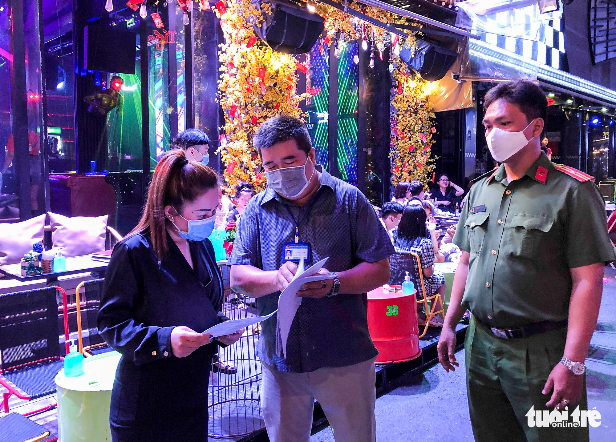 An official explains to a store owner the terms of a noise-reducing commitment during an inspection of businesses on Bui Vien Street in Ho Chi Minh City, Vietnam, March 20, 2021. Photo: Chau Tuan / Tuoi Tre