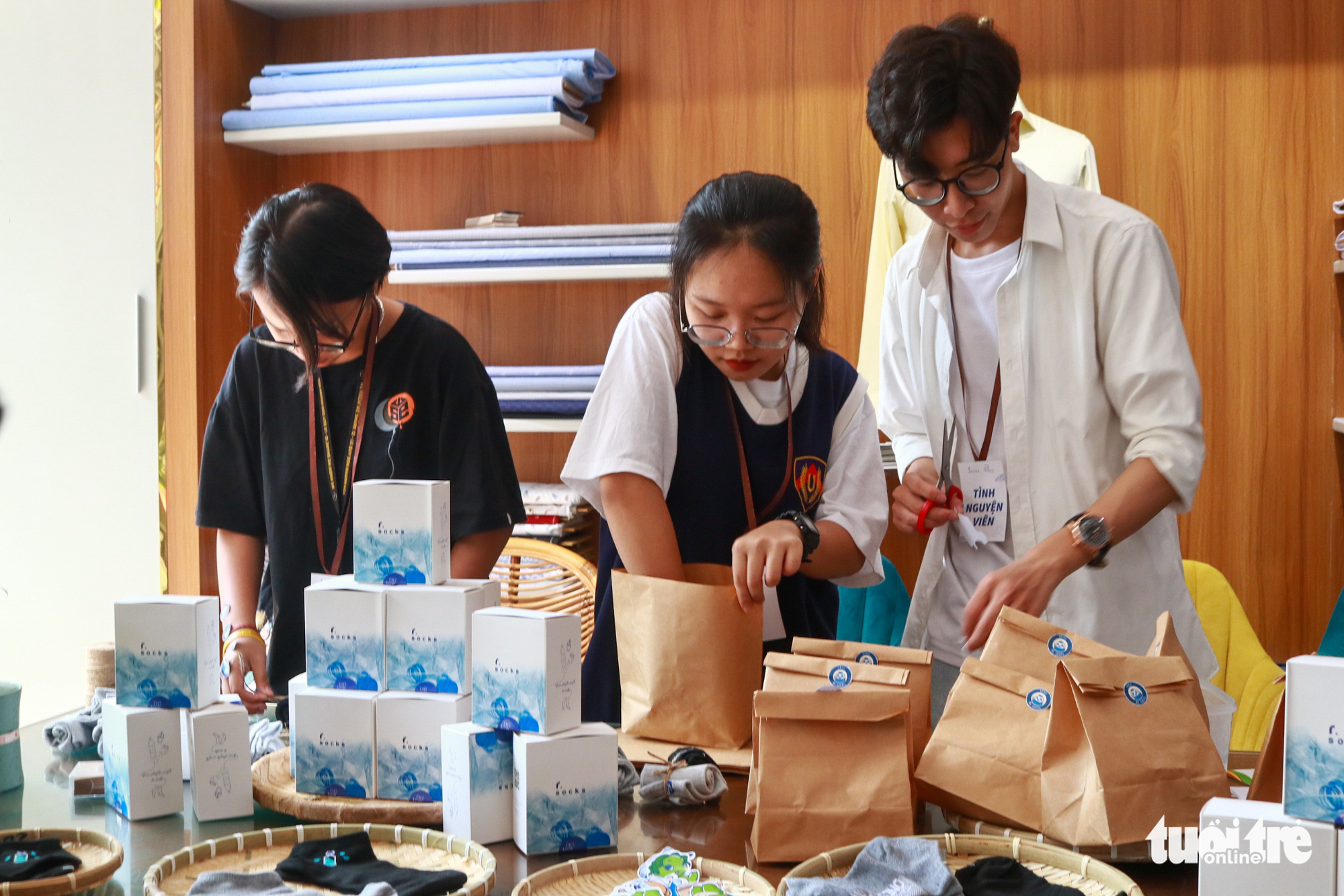 Volunteers put the eco-friendly socks into paper bags. Photo: Huu Huong / Tuoi Tre