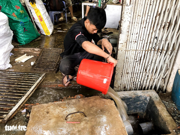 A resident on Nguyen Huu Canh Street in Ho Chi Minh City’s Binh Thanh District bails floodwater out of his house, April 4, 2021. Photo: Chau Tuan / Tuoi Tre