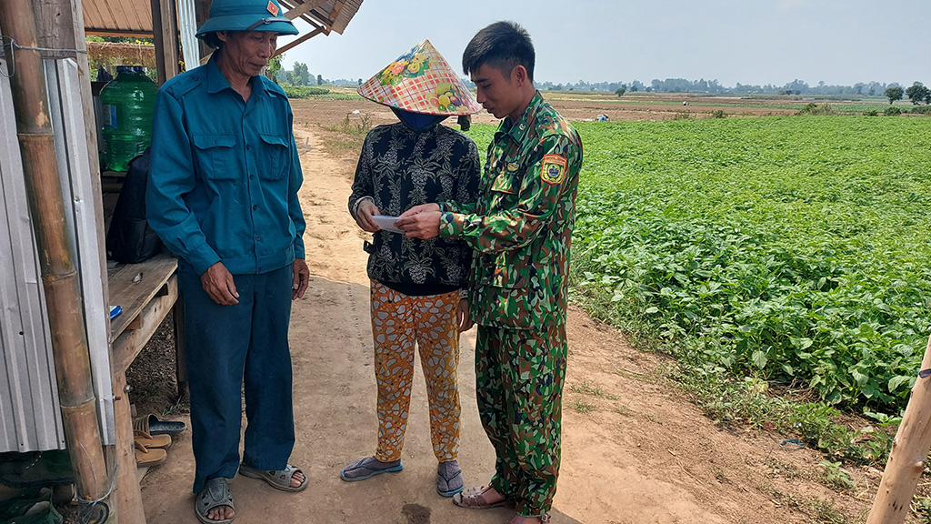 A border guard officer talks with local residents in An Giang Province, Vietnam. Photo: Buu Dau / Tuoi Tre
