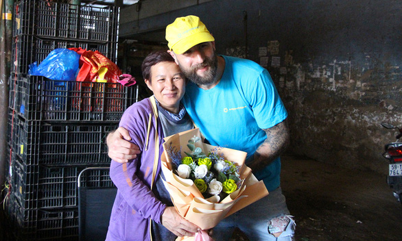 Phuong receives a bouquet of flowers from Scottish volunteer Mat Donald on International Women’s Day. – Photo: Kim Ut/Tuoi Tre