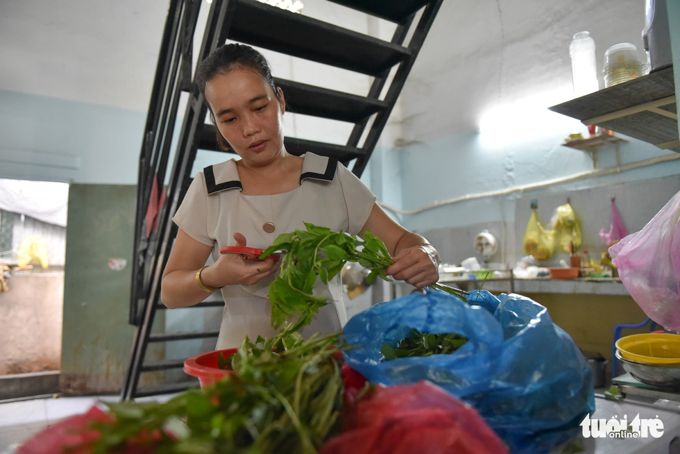 Tran Thi Quynh Mai is cutting vegetables to prepare a new day of serving diners with crab paste vermicelli soup. Photo: Ngoc Phuong / Tuoi Tre