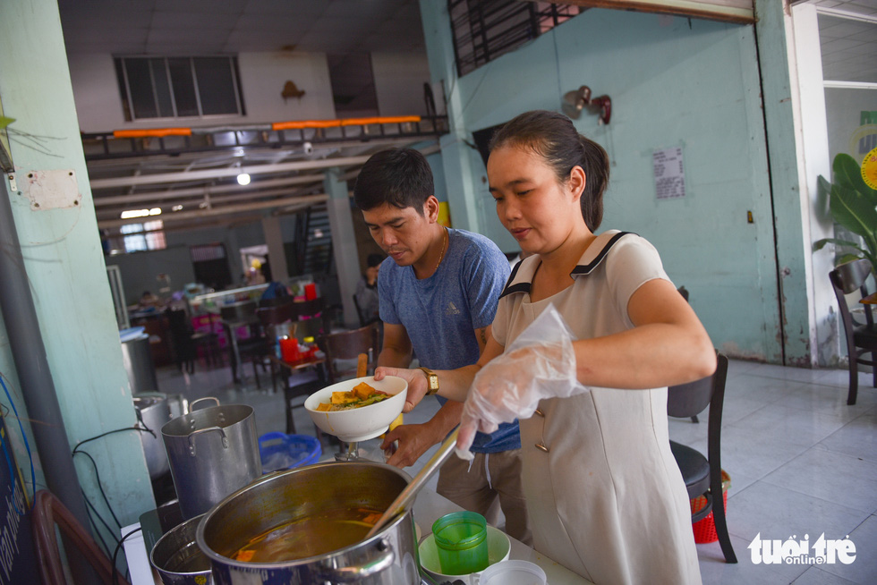 Tran Thi Quynh Mai is pouring soup into a bowl of crab paste vermicelli. Photo: Ngoc Phuong / Tuoi Tre