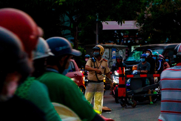 A traffic police officer maneuvers traffic in Ho Chi Minh City, April 15, 2021. Photo: Chau Tuan / Tuoi Tre