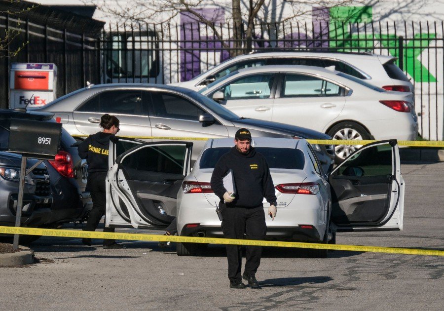 Crime scene investigators walk through the parking lot of the mass shooting site at a FedEx facility in Indianapolis, Indiana, on April 16, 2021. Photo: AFP