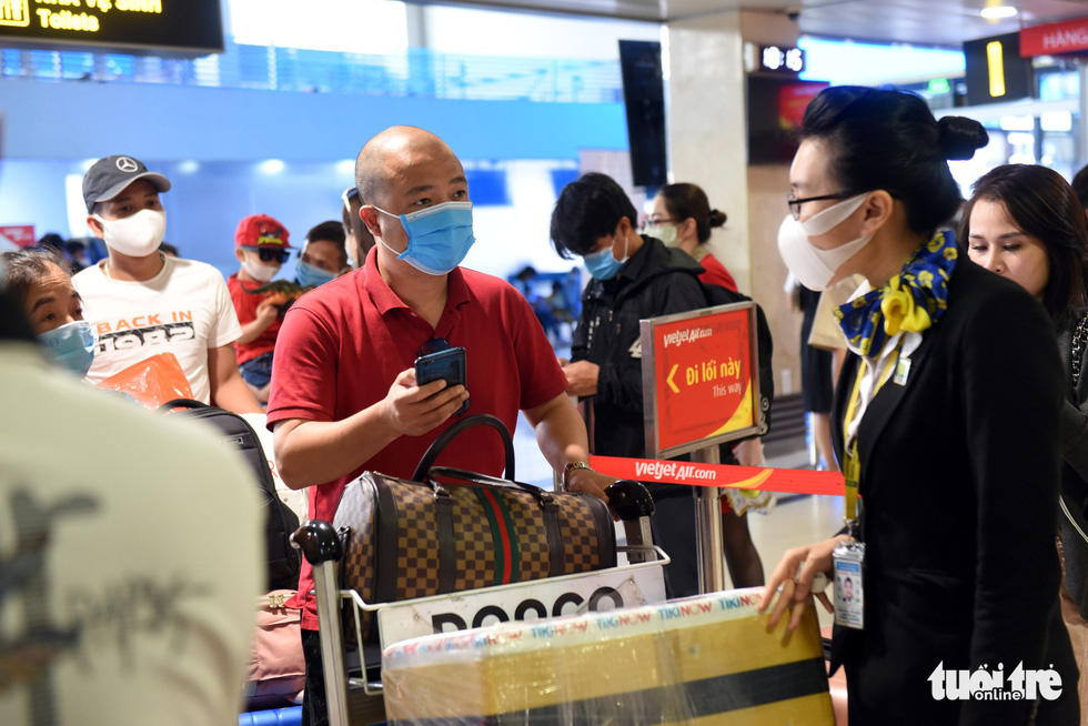 An airport employee requires passengers to present their medical declaration forms before allowing them to access check-in counters at Tan Son Nhat International Airport in Ho Chi Minh City, April 18, 2021. Photo: Tuoi Tre